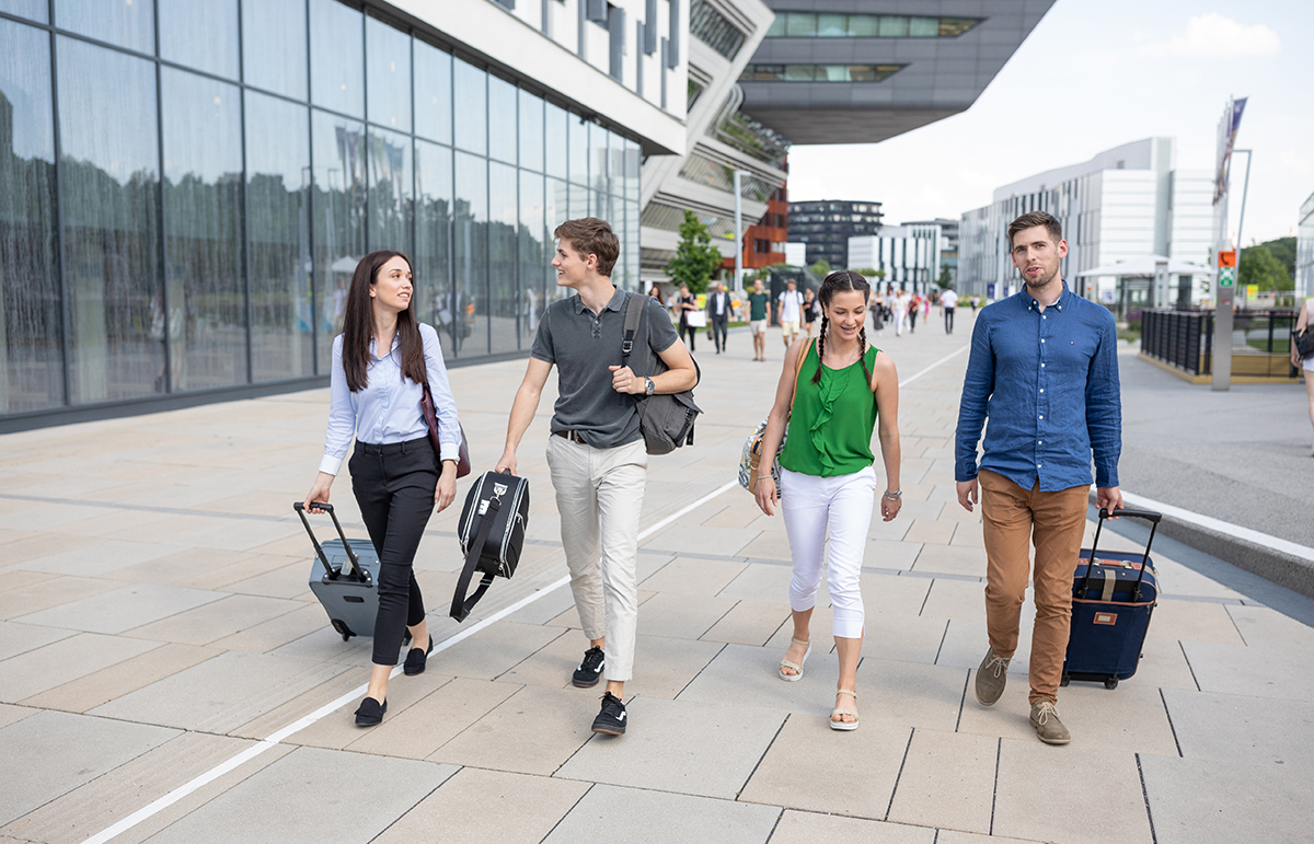 Studierende kommen mit Koffern auf den Campus (c) Raimo Rudi Rumpler